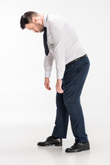 overweight man in tight formal wear bending over on white