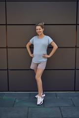 Fototapeta premium Schwangere junge Frau in Sportbekleidung