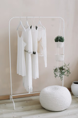 White dresses on a hanger. Minimalism concept. Set of women wedding dresses on a wooden hangers, fashion background, close up