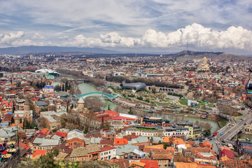 Fototapeta na wymiar Top view of the city of Tbilisi, sight-seeing, the glass bridge of the world across the Kura River in Europe Square. Beautiful landscape.