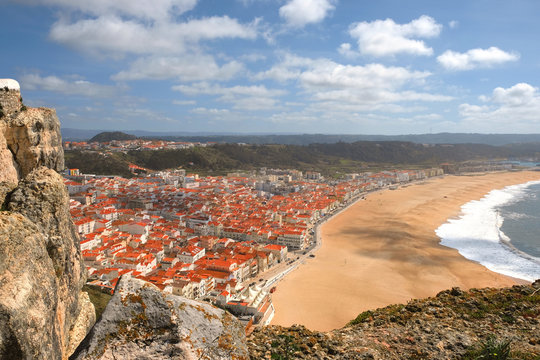 top view of the city of Nazare in Portugal, wide sandy beach and the Atlantic Ocean with waves