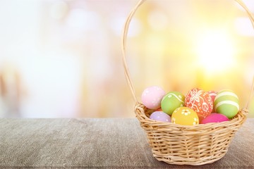 Easter basket filled with colorful eggs on a white background