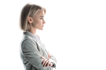side view of confident attractive businesswoman with crossed arms isolated on white