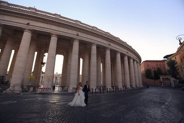 Obraz premium Beautiful wedding couple posing on street near old historic columns