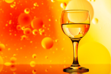 transparent glasses with water and oily drops on colorful background 