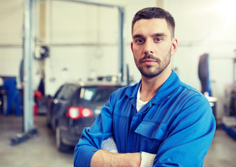 car service, repair, maintenance and people concept - auto mechanic man or smith at workshop