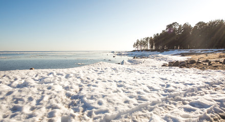 Snow pile, hill. Large snow drift isolated on a blue sky background,  outdoor view of ice blocks at frozen finland lake in winter