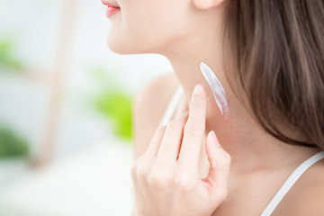 woman applying cream on neck