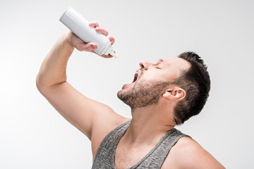 chubby man with open mouth holding bottle of whipped cream on white