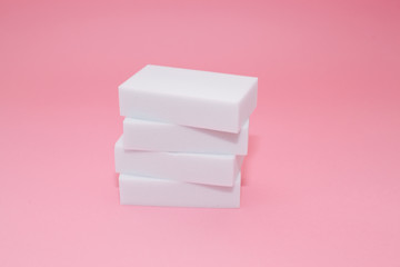 Melamine household sponge stack with four sponges for cleaning on pink background. Cleaning concept