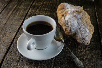 Cup of coffee and sweet buns on a rough wooden background