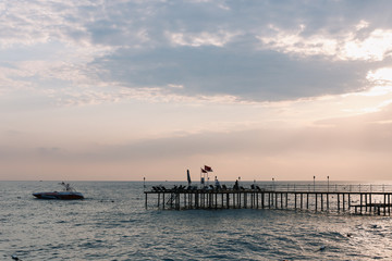 A pontoon on the mediterranean sea at sunset. Sea horizon and sunset sky. Vacation concept.