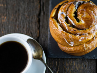 Cup of coffee and sweet buns on a rough wooden background