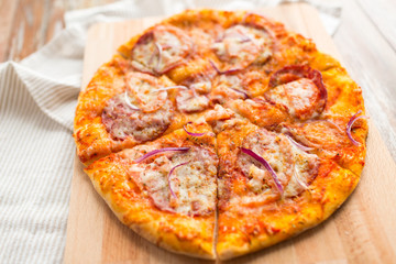 food, culinary and eating concept - close up of sliced homemade pizza on wooden table