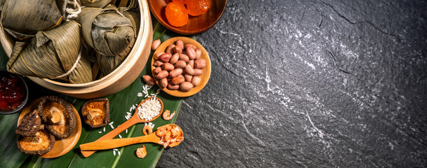 Close up, copy space, top view, flat lay. Famous asian chinese tasty handmade food in duan wu event, steamed rice dumplings shaped like pyramidal ingredient on black slate