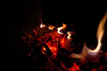 Glut eines Lagerfeuers mit kleinen Flammen in der Nacht