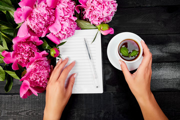 Woman hand writing diary, or letter, note with cup of coffee.