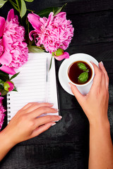 Woman hand writing diary, or letter, note with cup of coffee.