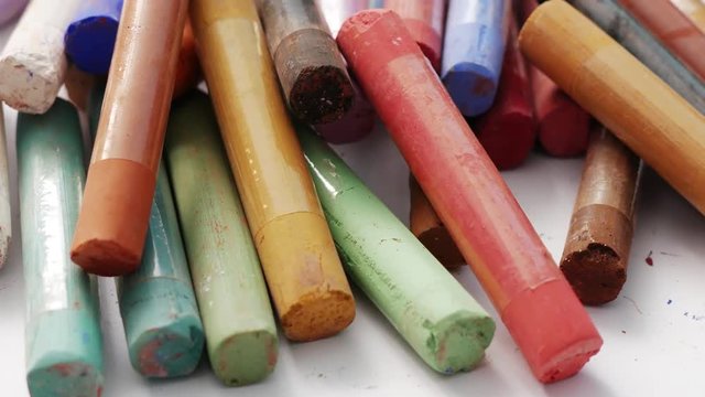 Close-up of a set of pastel crayons paint. Colorful chalks. Accessories for painting with pastels. Concept school of art and drawing training. Soft focus.