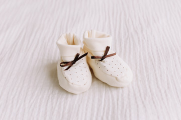 Baby's boots on white background. Waiting for baby. white shoes for newborn  on a pastel blue background. 