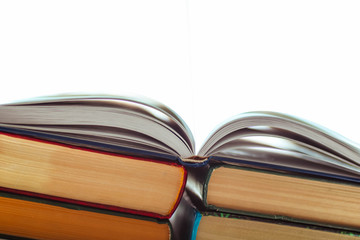 An open book on a pile of other books. Concept for education. Pure white light coming out of an open book.