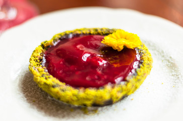 A sweet dessert with willd strawberry jam decorated with yellow flower 