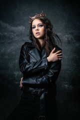 Young woman wearing a crown, a leather jacket, a hand on the shoulder