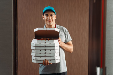 Delivery man shows fresh pizza, delivering service