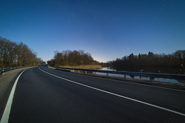 Turn of a highway at bright Moonlight night