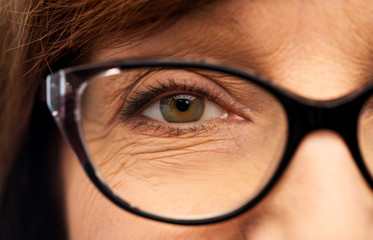 beauty, vision and old people concept - close up of face of senior woman in glasses