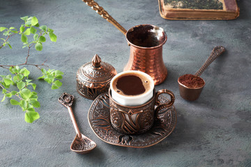 Oriental coffee cooked in traditional Turkish copper coffee pot and  served in a matching cup - obrazy, fototapety, plakaty