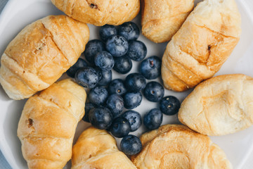 healthy light breakfast. blueberries, croissants on a plate. close up, top view. proper nutrition for a slim figure. raw food vegetarianism. diet
