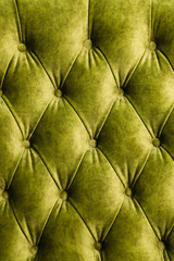 Velor lime surface of sofa close-up. Training equipment-velor mats tightened with buttons. Yellow chesterfield style quilted upholstery background