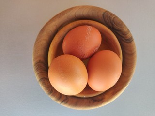 Raw fresh eggs in bowl on white background