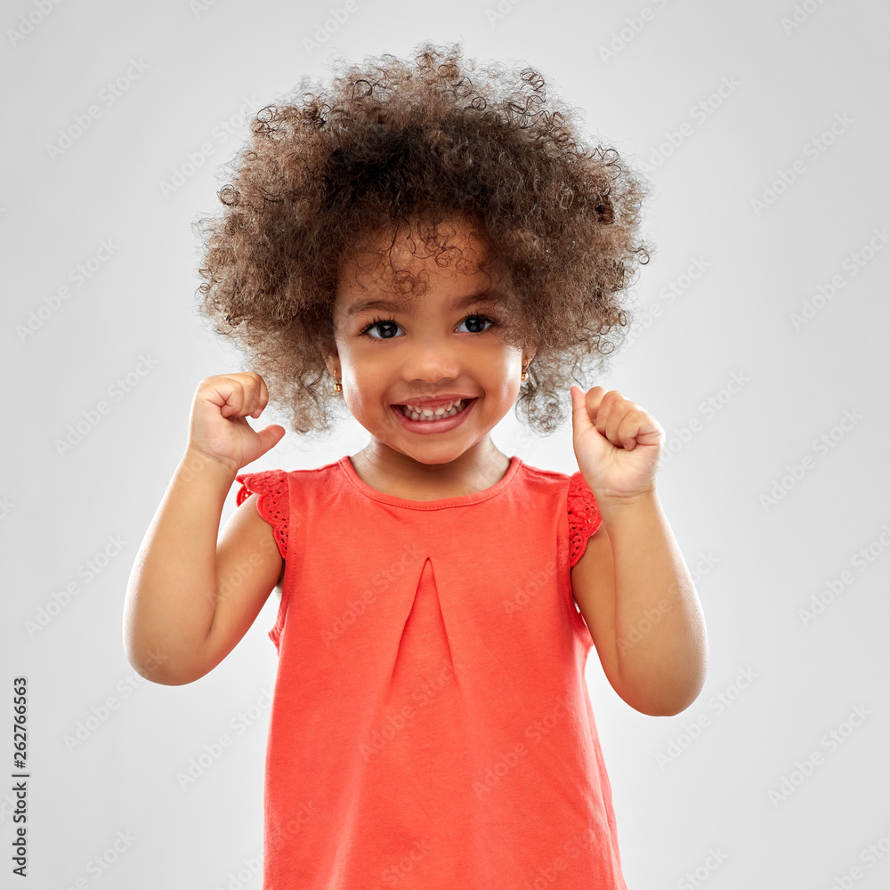 Wall mural childhood and people concept - happy little african american girl over grey background