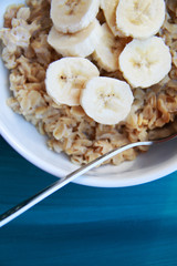 oatmeal with banana in white bowl, healthy breakfast