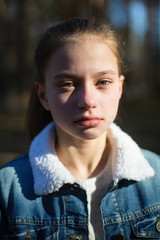 Closeup portrait of cute twelve year old girl outdoors.