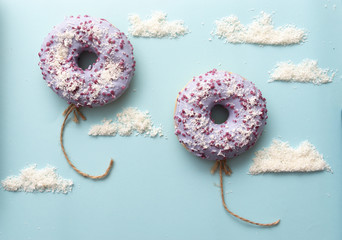 Concept purple donuts on a blue background with clouds minimalism