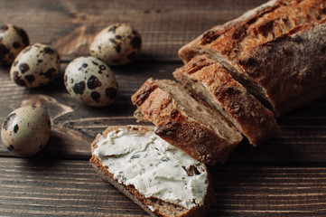 Bread on a wooden table with cheese and eggs