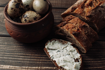 Bread on a wooden table with cheese and eggs