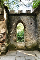 Naklejka premium Ancient stone ruins in a leafy garden of Sintra