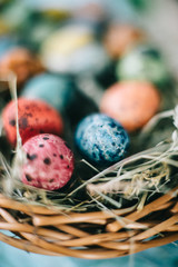 Quail Easter eggs in a basket on the hay. Easter concept