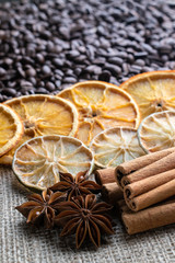 coffee beans with citrus cinnamon sticks and star anise on the background of burlap