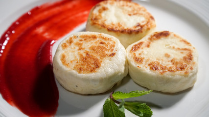 Three cheese pancakes on a plate with sauce