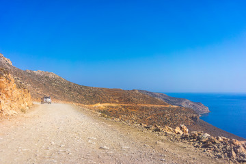 Fototapeta na wymiar Car on the mountain road on the way to the beach of Balos in Crete