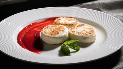 Three cheese pancakes on a plate with sauce