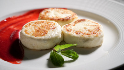 Three cheese pancakes on a plate with sauce