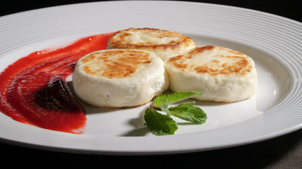 Three cheese pancakes on a plate with sauce