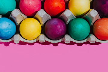 Easter background with Easter eggs. Top view with copy space. multicolored Easter eggs on a pink background