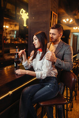 Man and woman relax, couple at wooden bar counter
